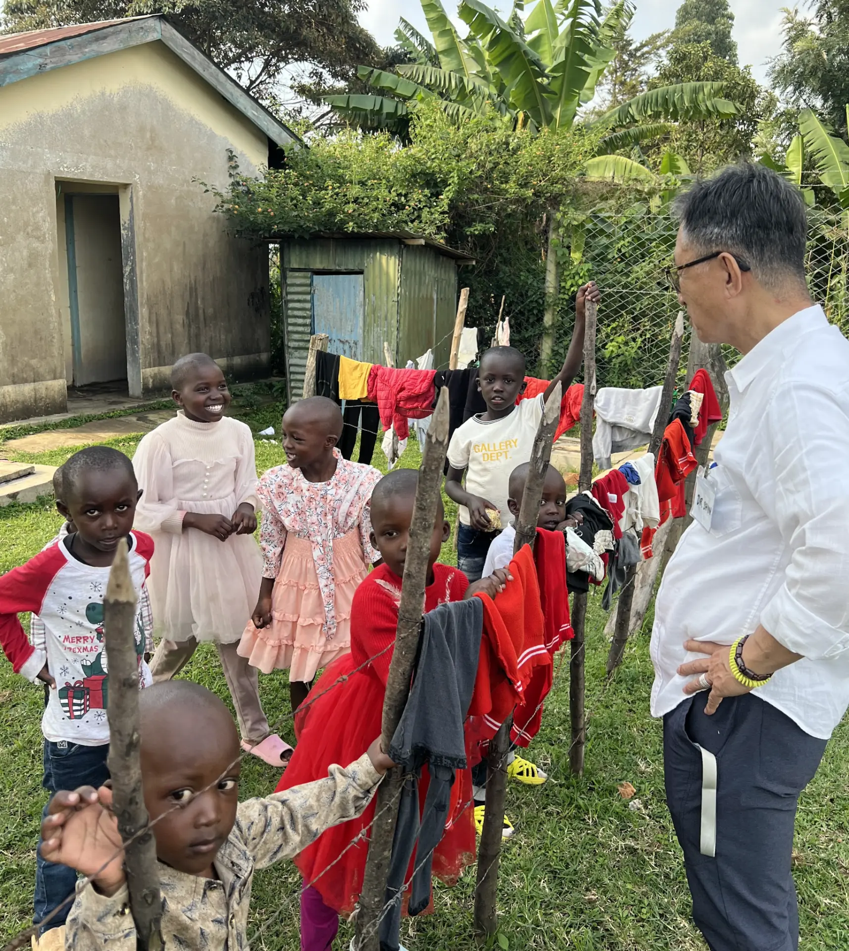 Dr. Shin greeting a group of children outside their home during a medical mission in Kenya